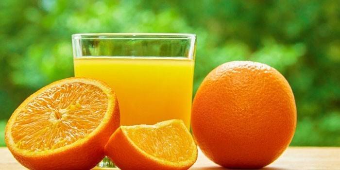 Апельсиновый сок в стакане и апельсины