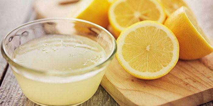Лимонный сок в креманке и половинки лимонов