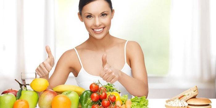 Девушка за столом с фруктами и овощами