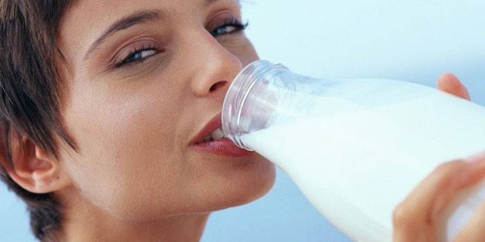 Девушка пьет молоко из бутылке