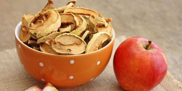 Сушеные яблоки в миске и свежий фрукт