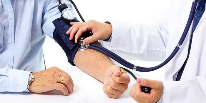 Медик измеряет артериальное давление пациента