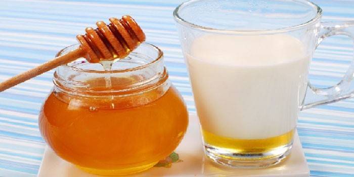 Мед в банке и чашка молока с медом