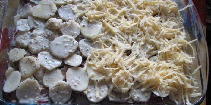 Слой картофеля и сыра в форме перед запеканием