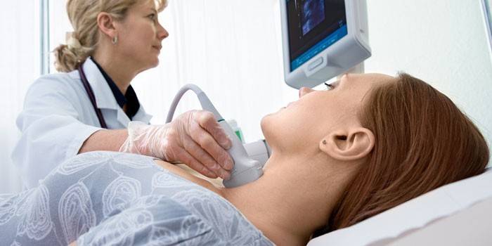 Женщине делают ультразвуковое исследование щитовидной железы