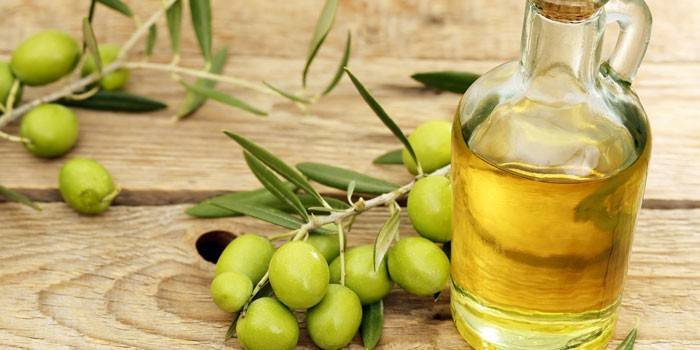 Оливковое масло в бутылке и зеленые оливки