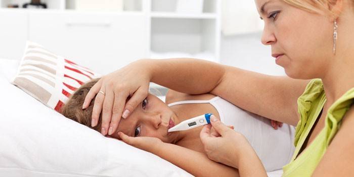 Женщина измеряет температуру ребенку