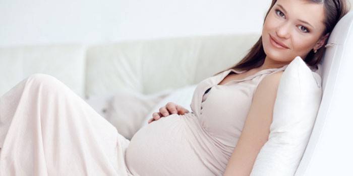 Беременная женщина отдыхает на диване