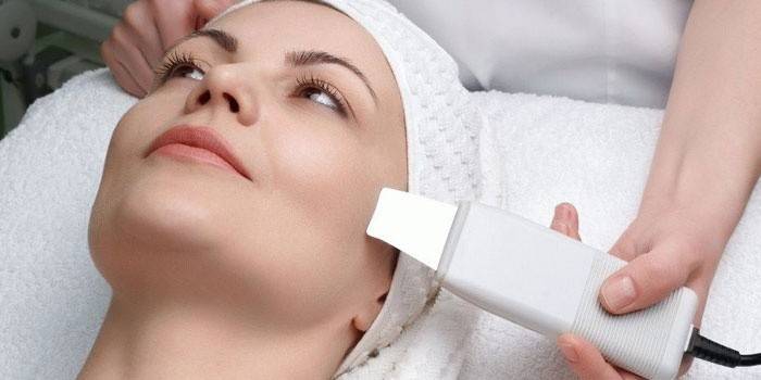 Косметолог проводит химическую чистку лица женщины