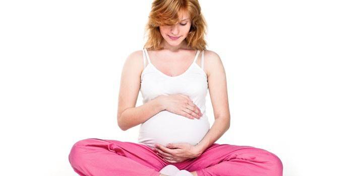 Беременная девушка в позе лотоса