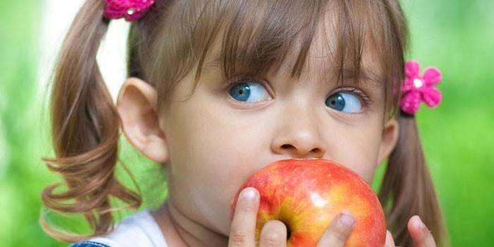 Девочка кушает яблоко