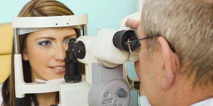 Офтальмолог проводит диагностику зрения девушки