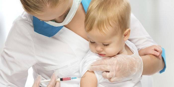 Медработник делает грудному ребенку прививку
