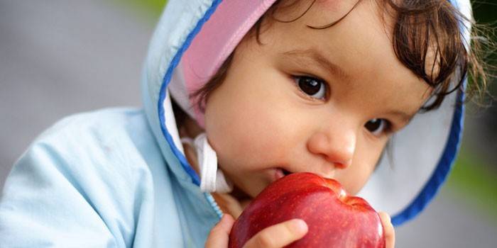 Ребенок кушает яблоко