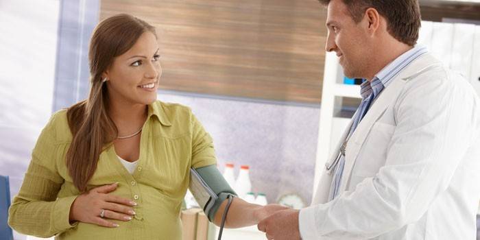 Врач измеряет беременной женщине давление