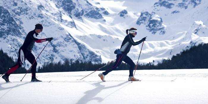 Мужчина и женщина бегают на лыжах