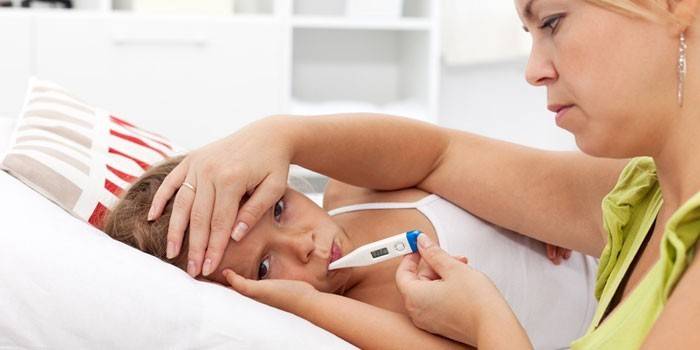 Женщина измеряет ребенку температуру