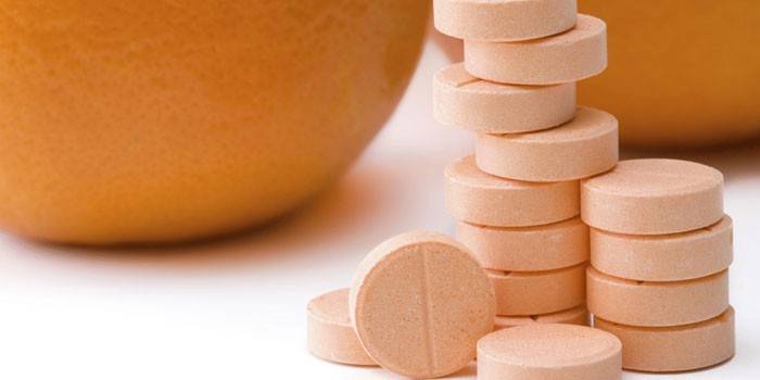 Витамин C в таблетках и апельсины