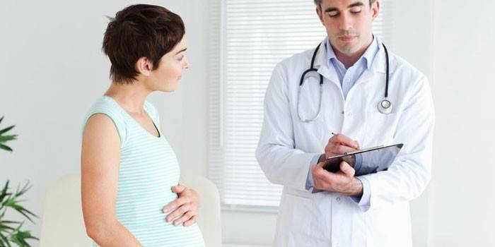 Беременная девушка беседует с врачом