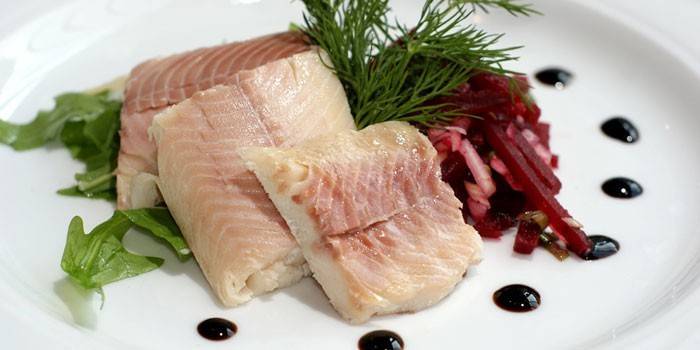 Рыбное филе с салатом на тарелке