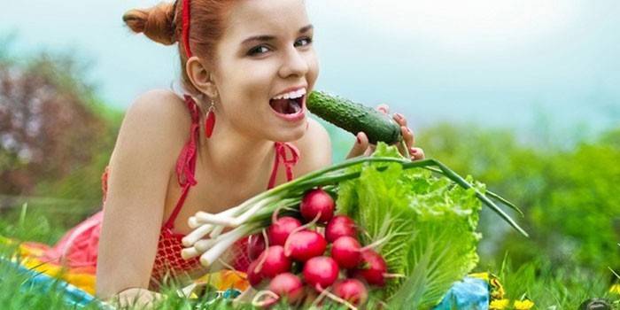 Девушка ест овощи с грядки