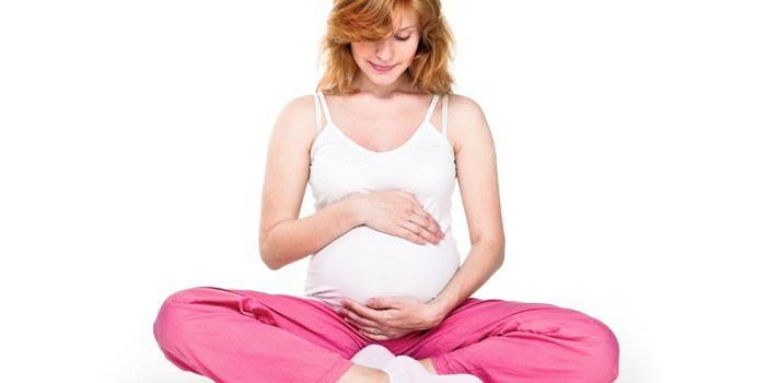 Беременная девушка в позе лотоса