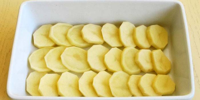 Слой кружочков сырого картофеля в форме
