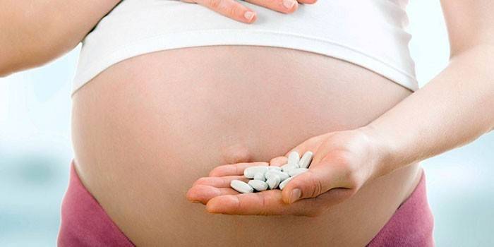 Беременная девушка с таблетками