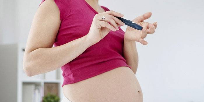 Беременная девушка проверяет уровень сахара в крови