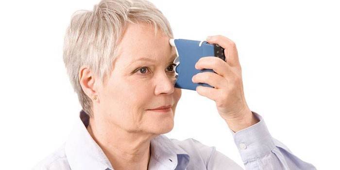 Пожилая женщина с бесконтактным аппаратом для измерения глазного давления