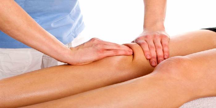 Медик делает массаж коленного сустава