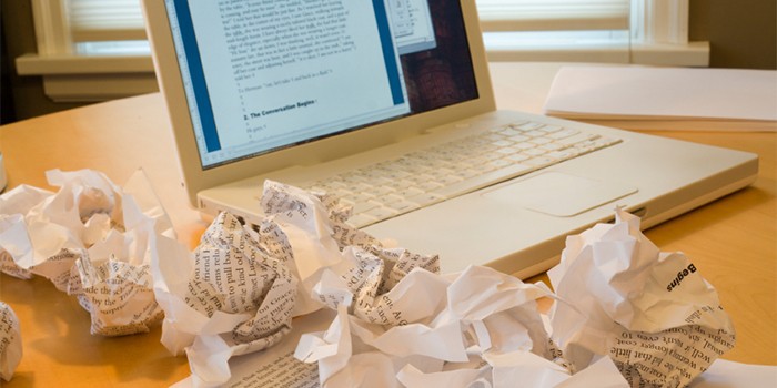 Ноутбук и смятые листы бумаги