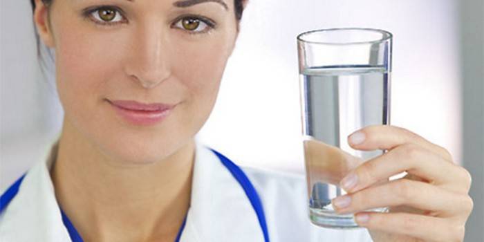 Медик со стаканом воды в руке