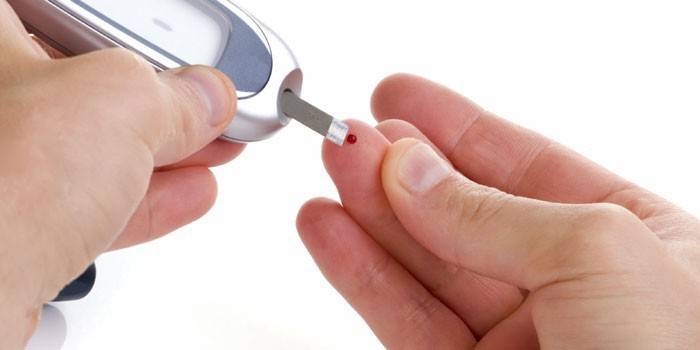 Мужчина измеряет уровень сахара в крови глюкометром