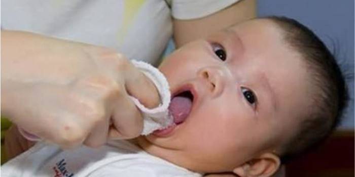 Женщина вытирает рот младенца