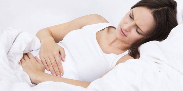Беременная женщина держится двумя руками за живот