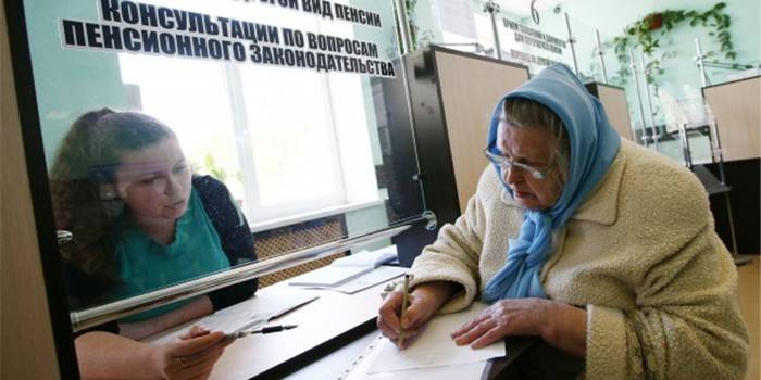 Женщина пенсионного возраста подписывает документы