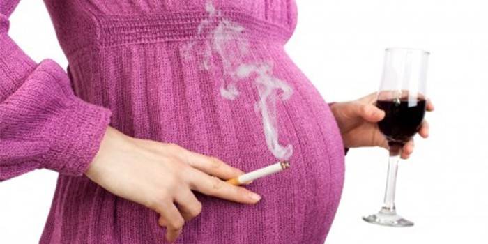 Беременная женщина с бокалом вина и сигаретой