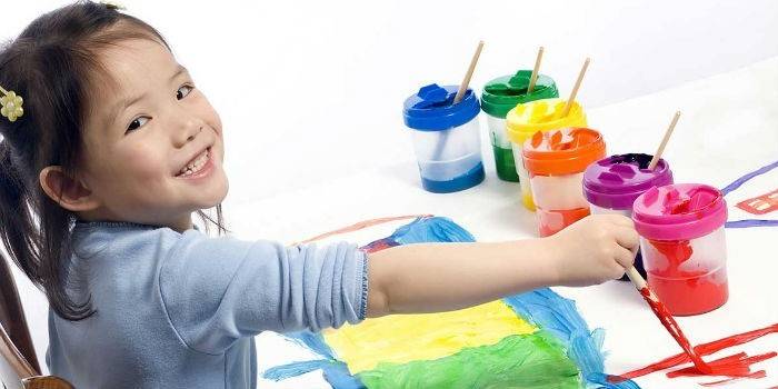 Девочка рисует красками