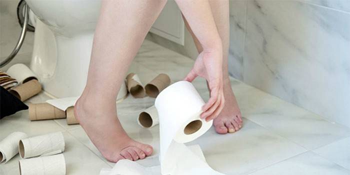 Женщина в туалете с рулоном туалетной бумаги