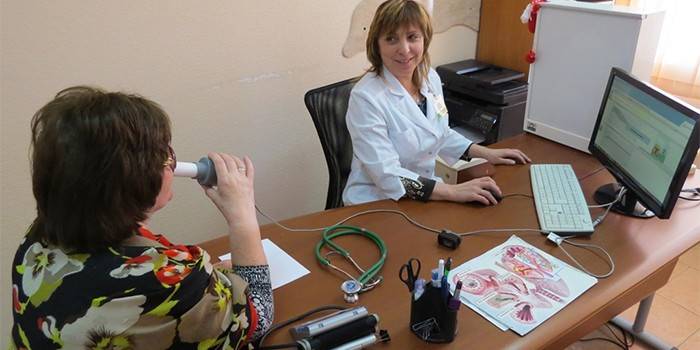Женщина проходит процедуру спирографии в кабинете врача