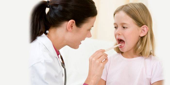 Доктор осматривает горло ребенку