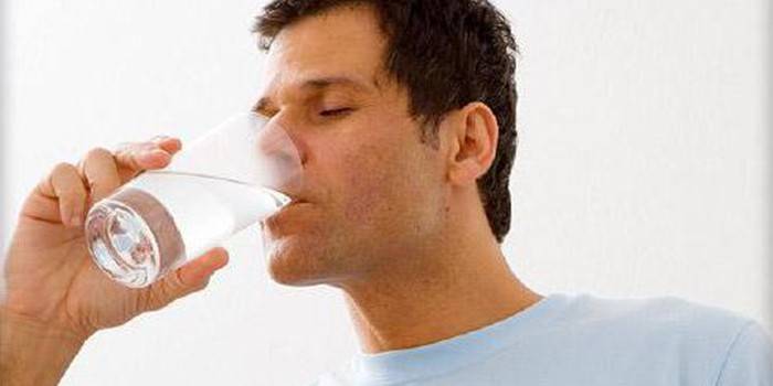 Мужчина пьет воду из стакана