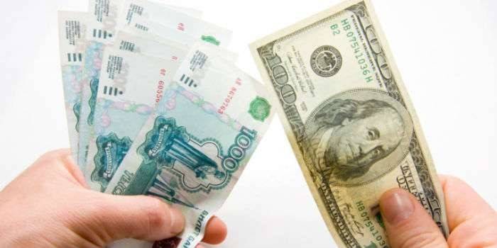 Рублеве и долларовые купюры в руках