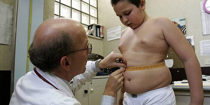 Доктор измеряет талию ребенка