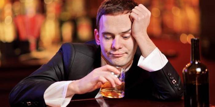 Мужчина со стаканом алкоголя в руке