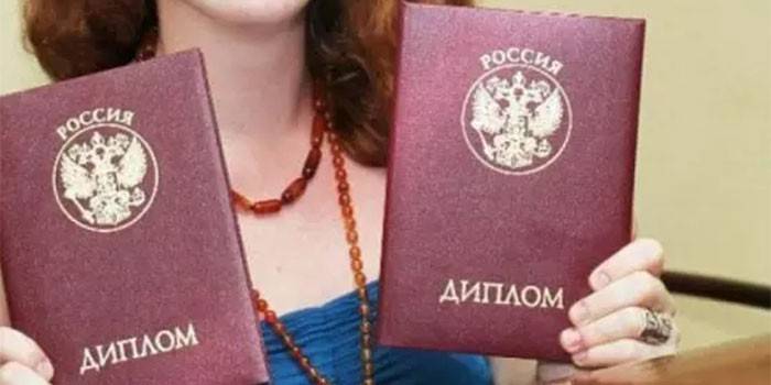 Девушка с двумя дипломами в руках