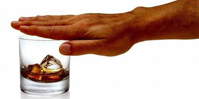 Мужская рука закрывает бокал с алкоголем