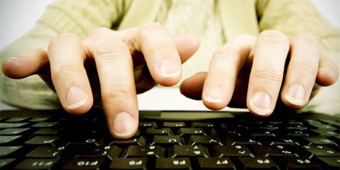 Пальцы человека над клавиатурой компьютера