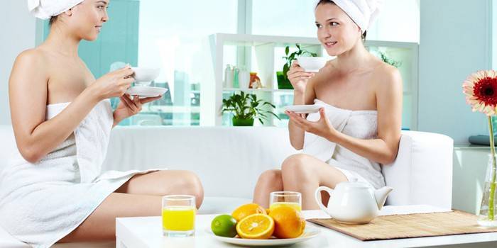 Две девушки пьют чай и сок в спа-салоне